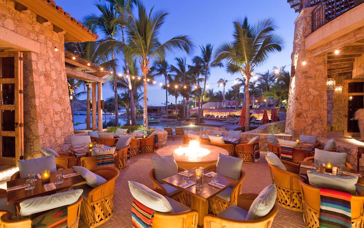 Chairs and tables set in the courtyard around a fire